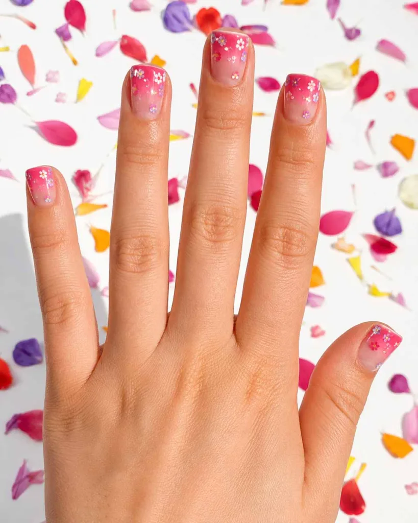 Short square jelly pink ombre nails with tiny multicolor floral confetti decals sealed under a glossy gel top coat