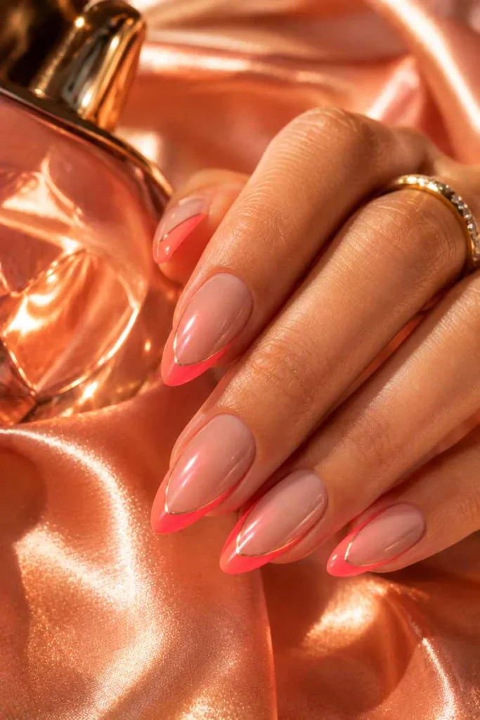 Bold portrait close-up of glossy nude almond nails with neon coral aura French tips and chrome accents for summer nail design ideas 2026.