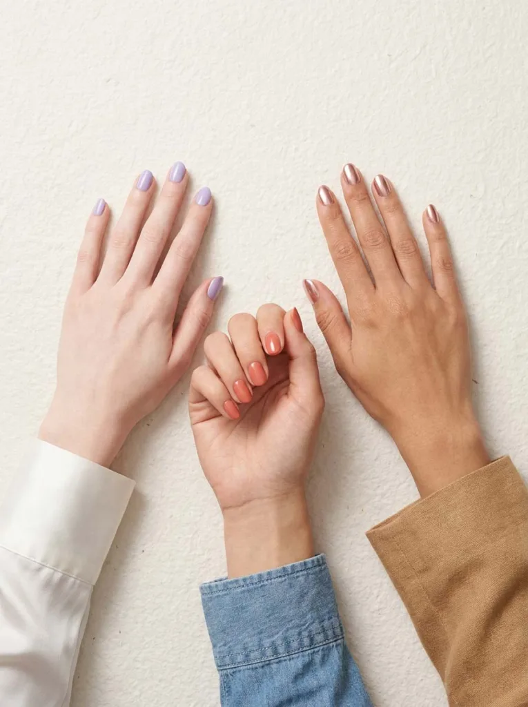 Three hands with different nail designs matched to fair, medium, and deep skin tones for classy short nails