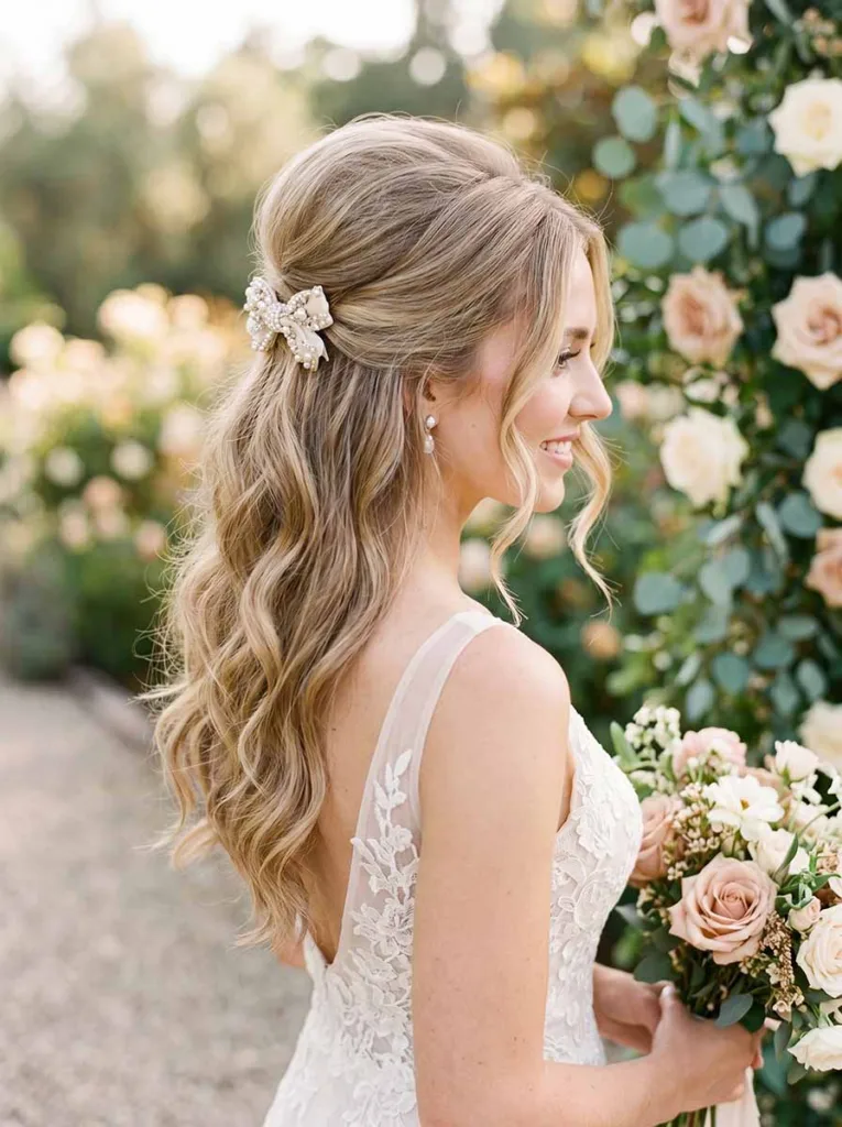 Elegant bridal half-up hairstyle with crown volume and embellished clip for wedding