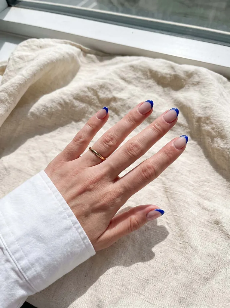 reinvented lavender French tip almond nails on shimmery rose base fair skin hand resting on linen