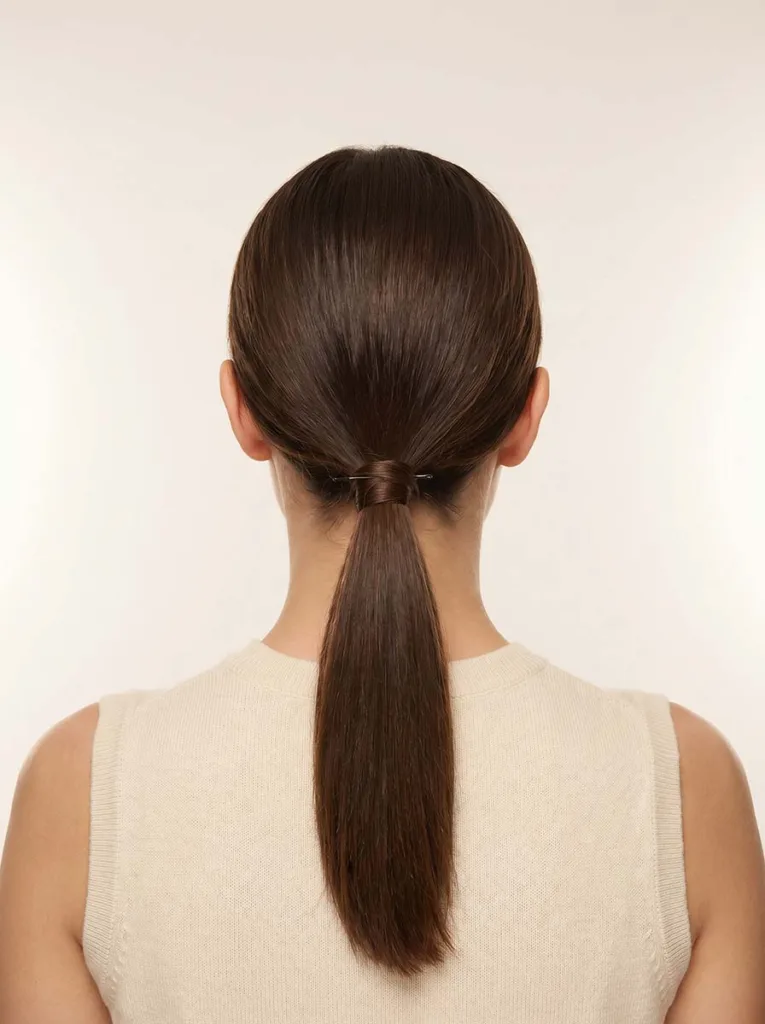 low sleek ponytail with wrapped hair tie on brunette hair easy hairstyle