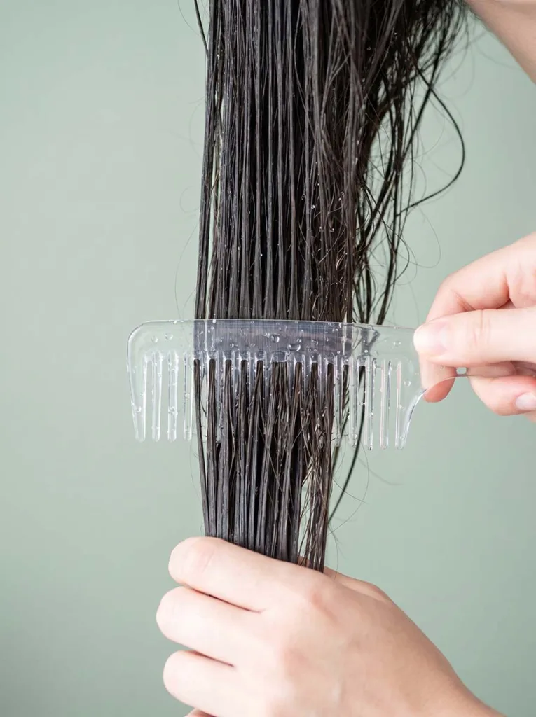 wide-tooth comb detangling wet hair from ends to roots to prevent breakage