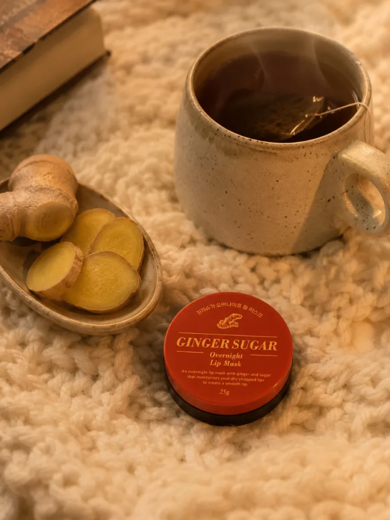 Aritaum Ginger Sugar overnight lip mask beside a warm blanket and tea