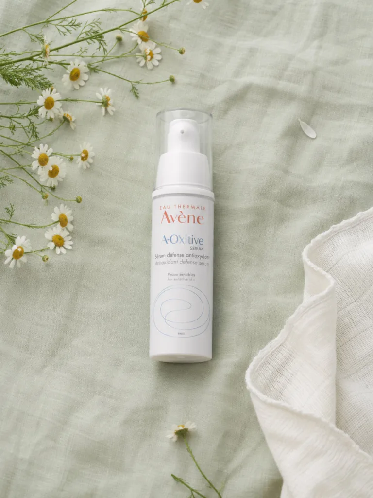Avene A-Oxitive Antioxidant Defense Serum bottle with chamomile on linen