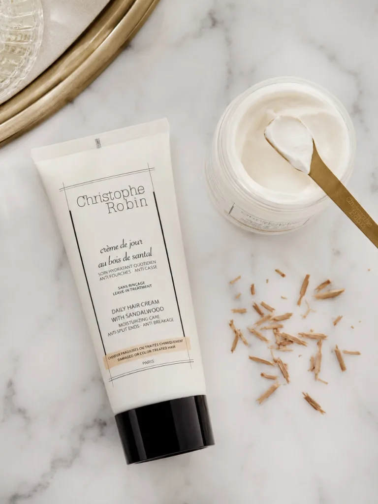 Christophe Robin Hydratant Santal styling cream jar in an elegant marble flat lay