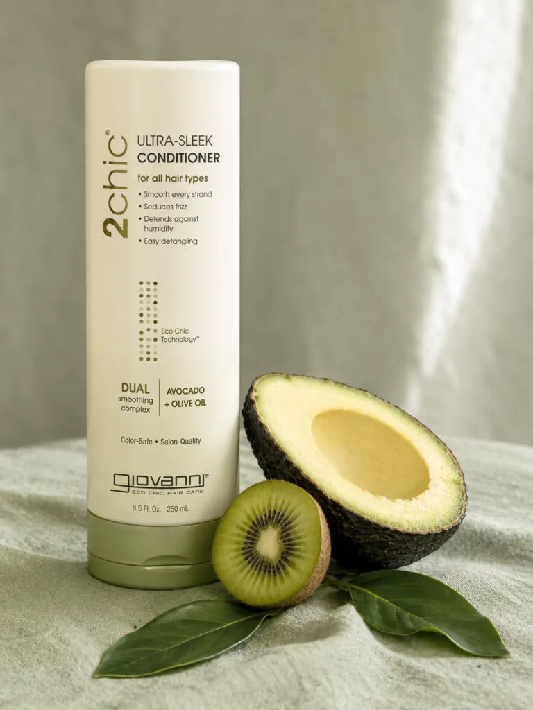 Giovanni 2chic ultra-sleek conditioner bottle with avocado half and kiwi slice on sage green linen surface