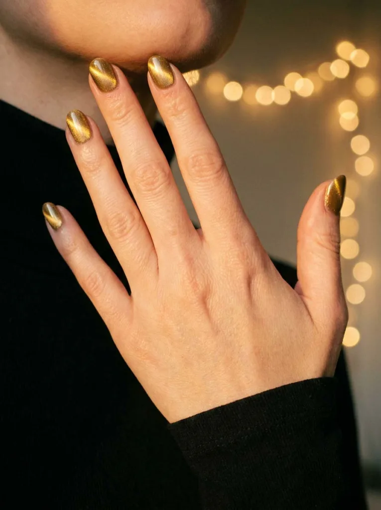 Gold cat-eye winter nails with shimmer light band effect