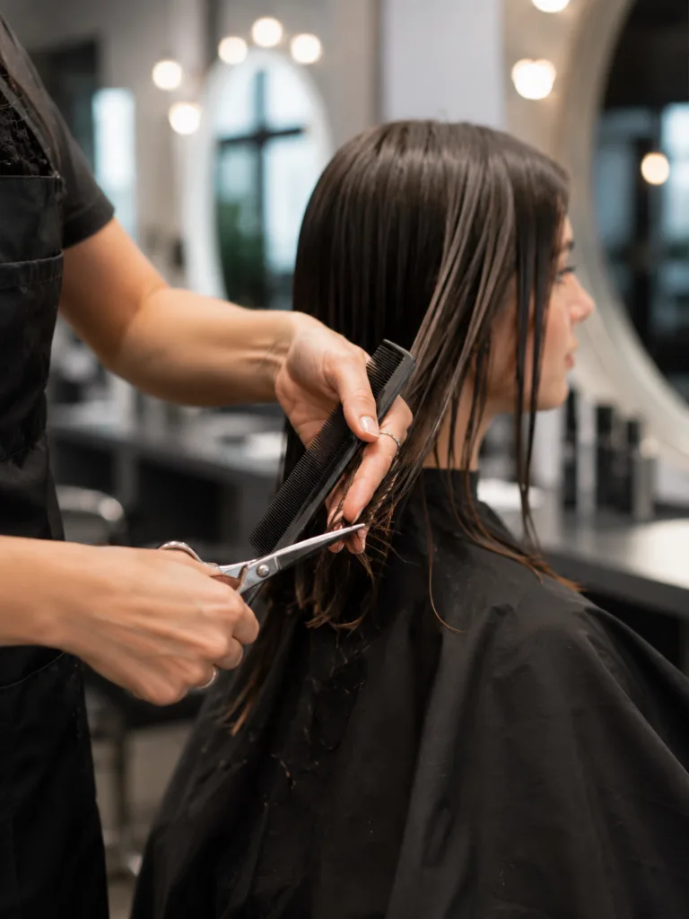Hairstylist trimming split ends during a routine hair appointment