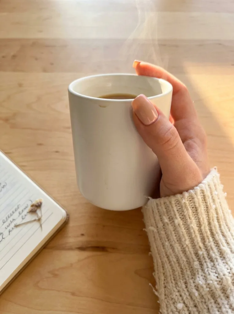 Neutral Beige Satin Nails Wrapped Around a White Ceramic Coffee Mug
