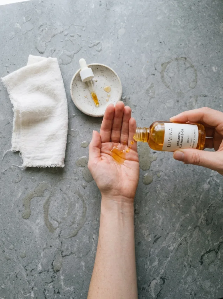 Overhead shot of hands pouring korean cleansing oil into a palm during the double cleanse