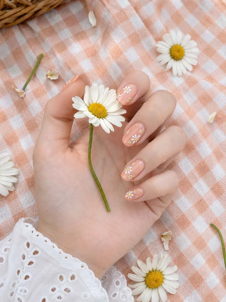 Peach blooms floral nail art on fair skin with real daisies