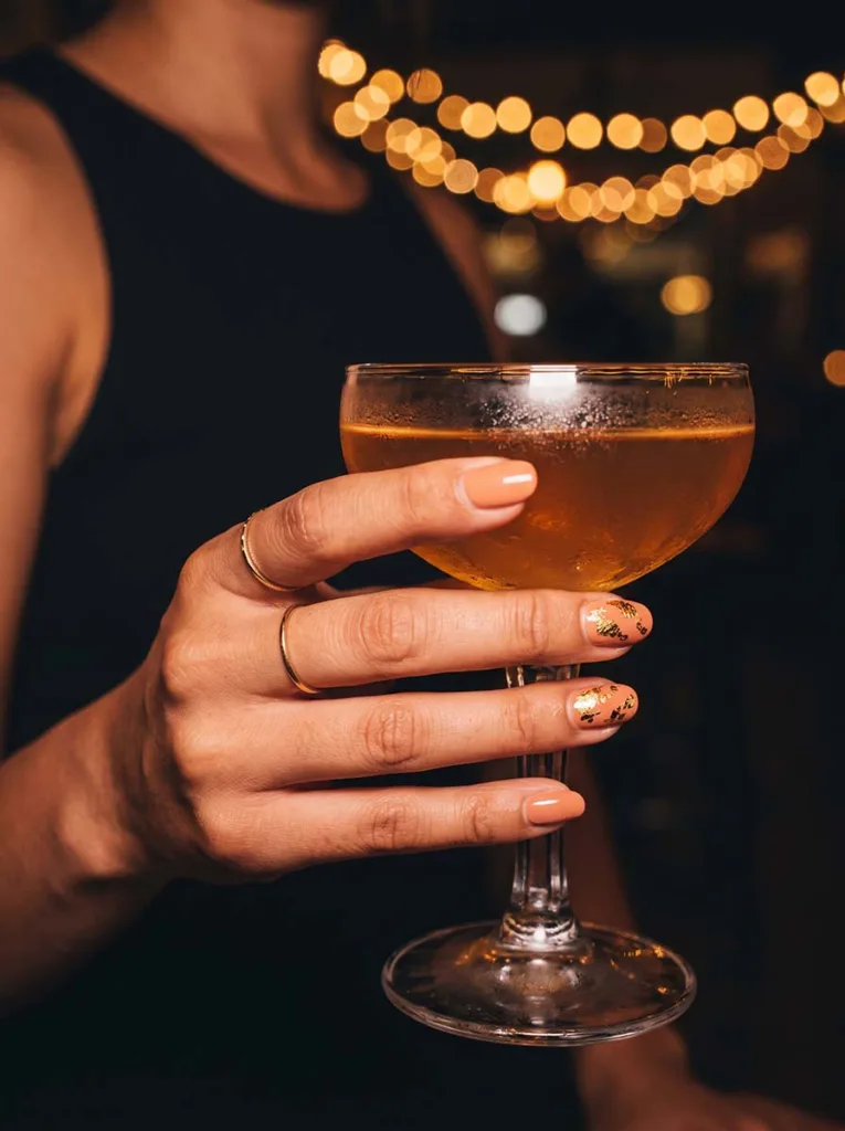 Peach and gold accent nails at an evening event