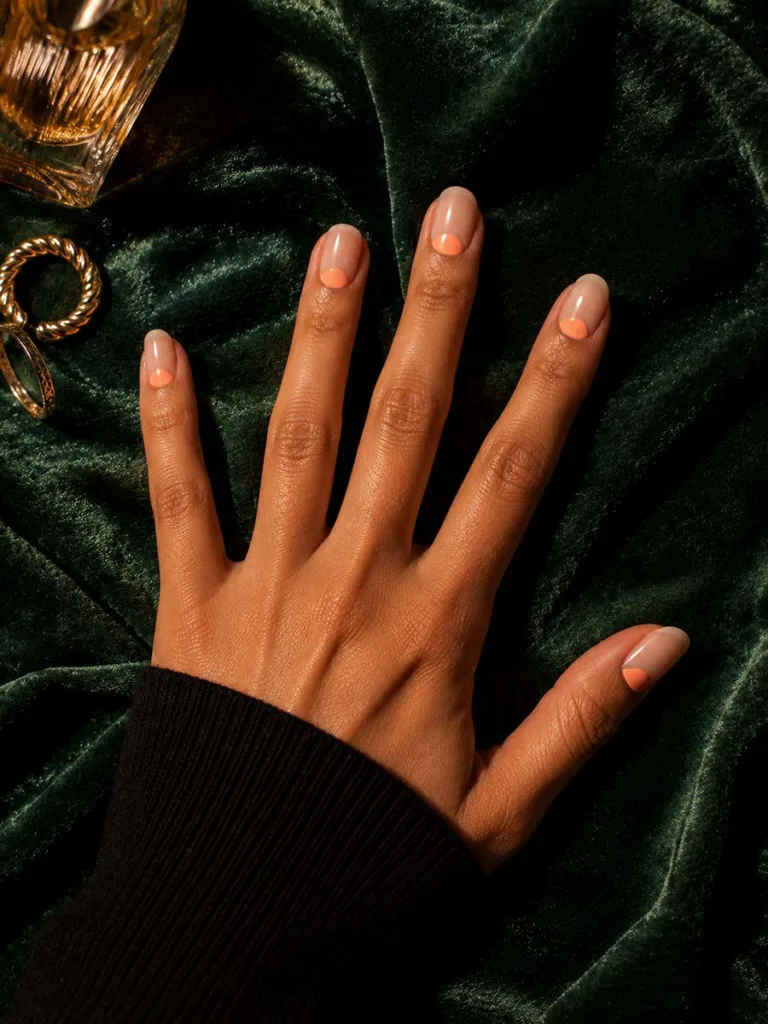 Reverse French manicure with peach cuffs on medium skin tone