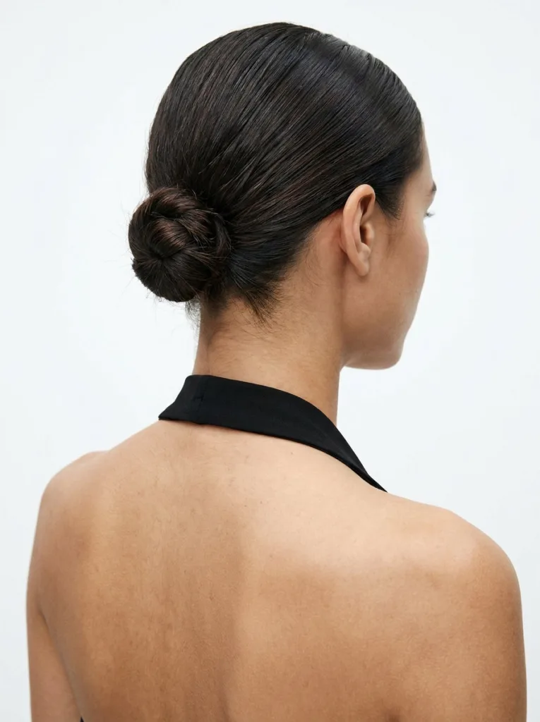 Close-up of a slicked nape knot updo, an easy holiday hairstyle for short hair.