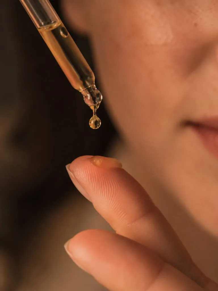 Close-up of a natural vitamin C serum drop being applied to skin at night