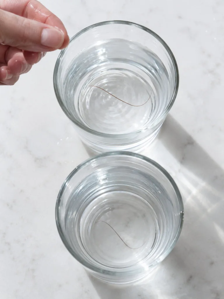 Hair porosity water test showing floating and sinking hair strands