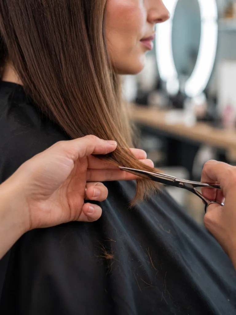 Hairstylist trimming the ends of long hair to prevent split ends