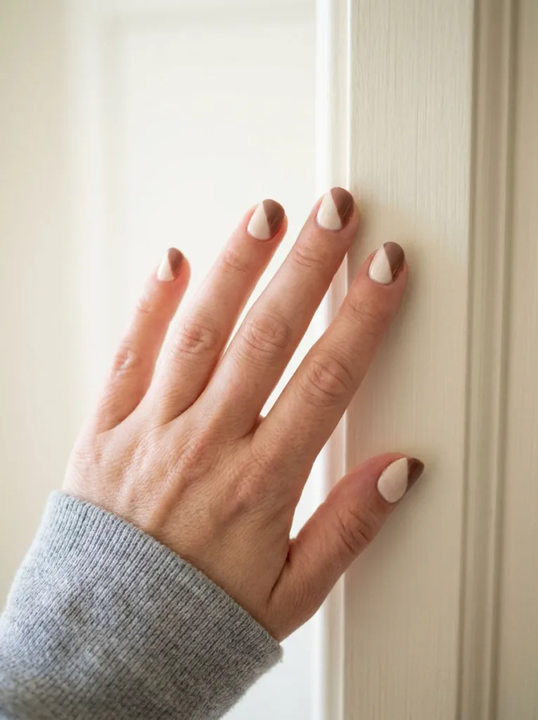 Close-up of two-tone cream and brown dip powder nails