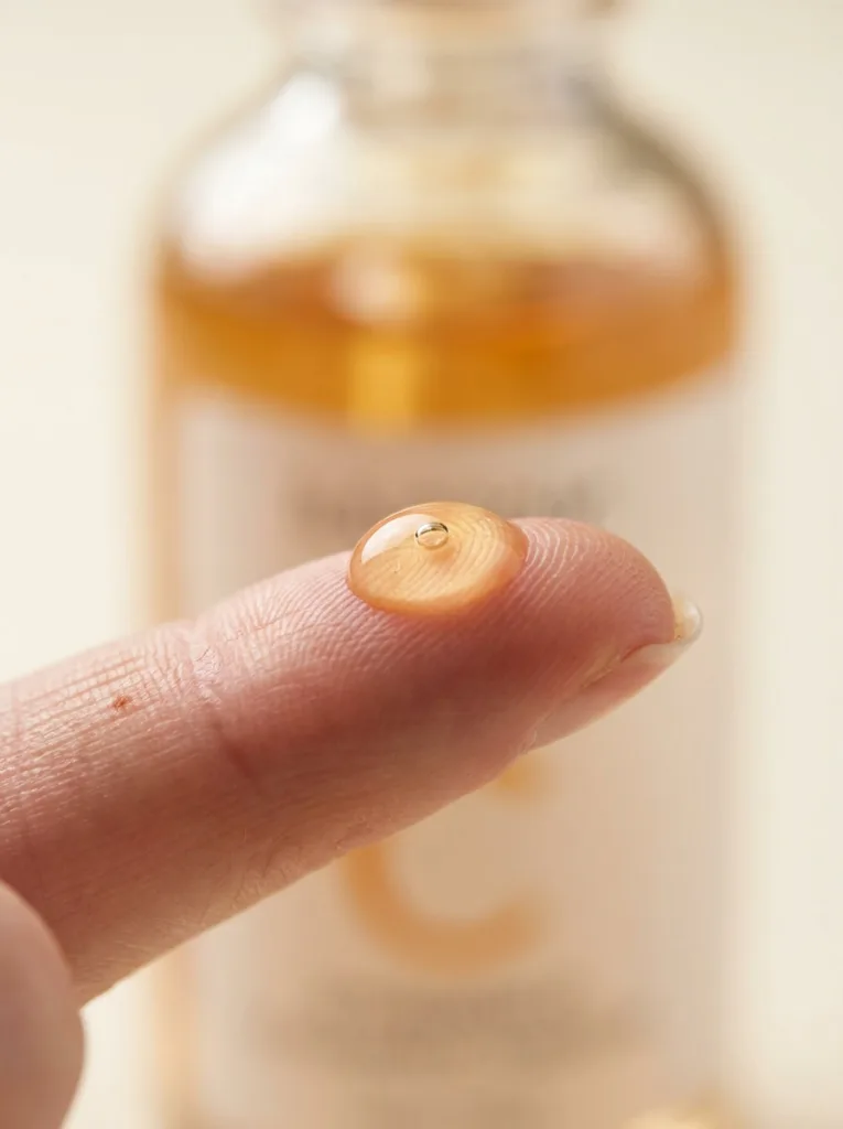 Macro close-up of a vitamin C serum droplet absorbing into skin