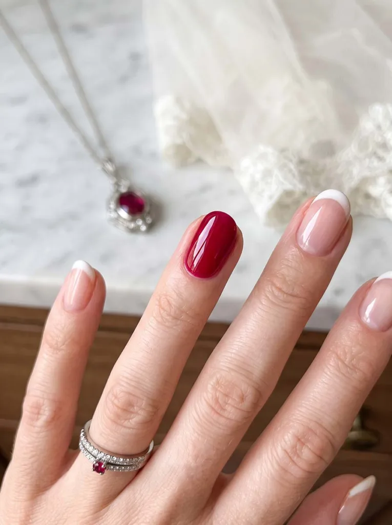 close-up of a birthstone-colored accent wedding nail beside matching jewelry