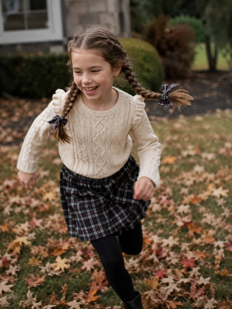 Child with double braided pigtails Thanksgiving hairstyle playing outside