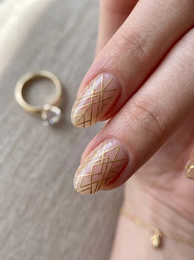 close-up of fine gold line art wedding nails beside wedding rings