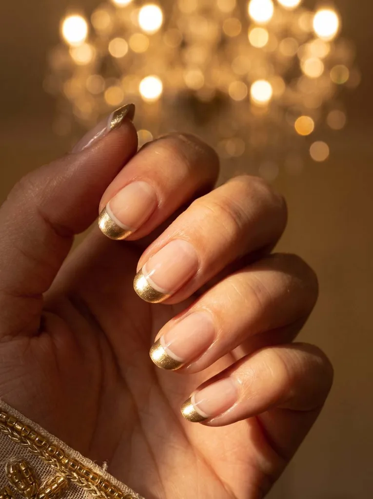 close-up of metallic gold French tip wedding nails