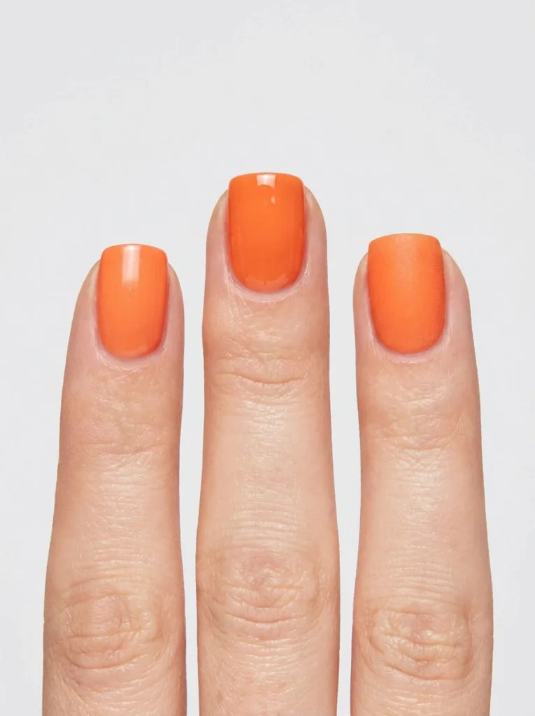 Three fingers comparing regular, gel, and dip orange nail polish finishes