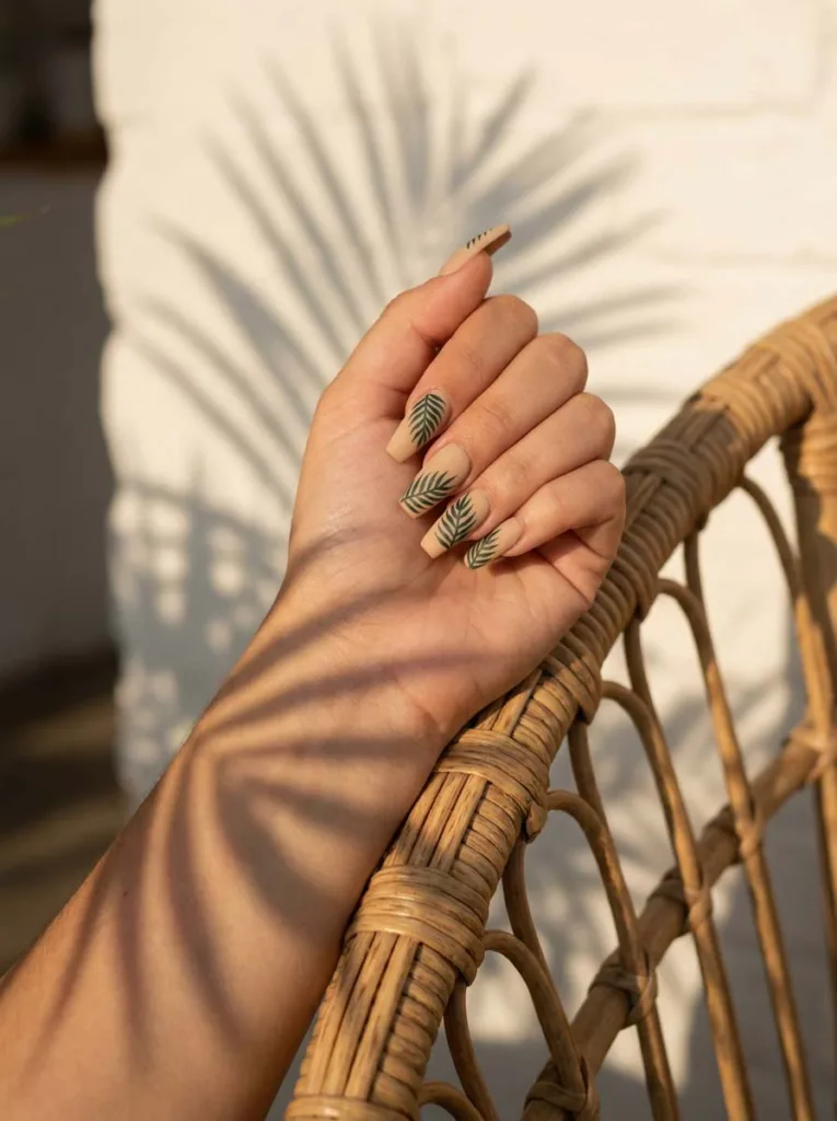 Palm leaf silhouette summer nails on a rattan chair with natural palm shadow