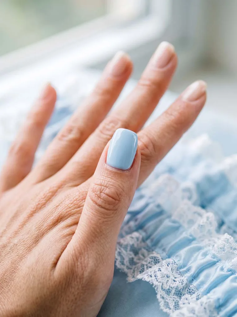 close-up of a something blue wedding nail accent beside a blue garter