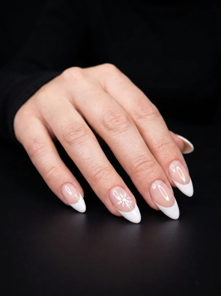 Negative space French tip nails with a snowflake accent
