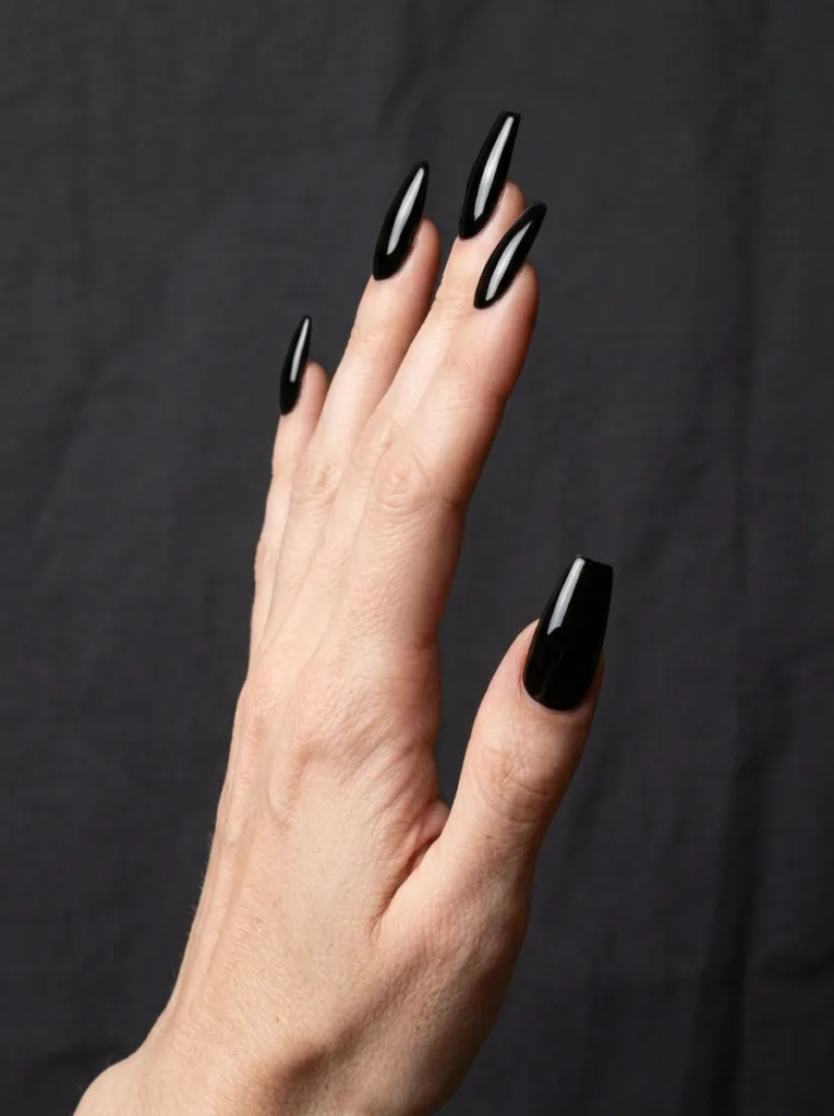 Close-up of a hand extended sideways, long almond-shaped black manicure