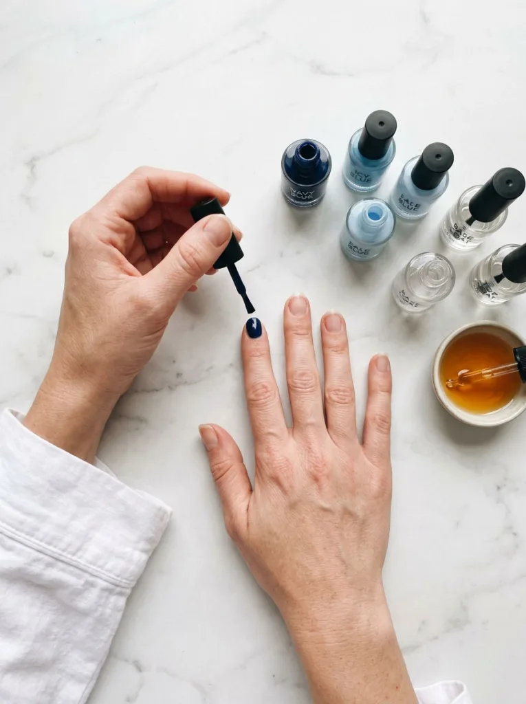 Applying blue winter nails polish step by step at home