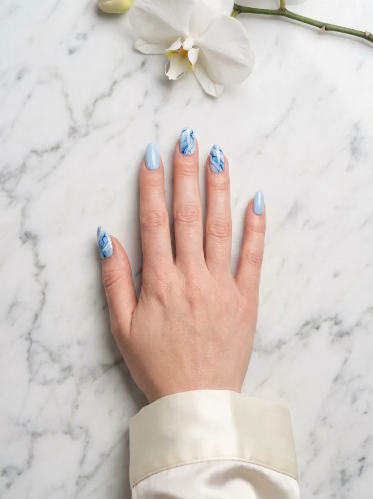 Blue and white marble winter nails on accent fingers