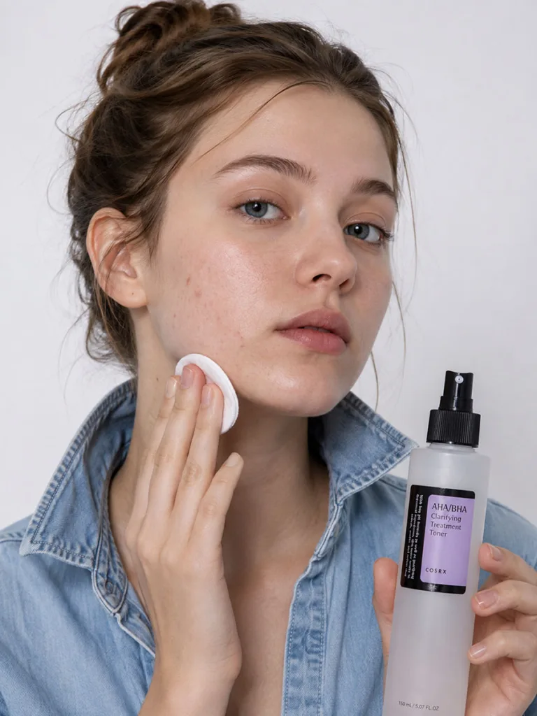 Woman applying COSRX AHA BHA toner with a cotton pad along her jawline