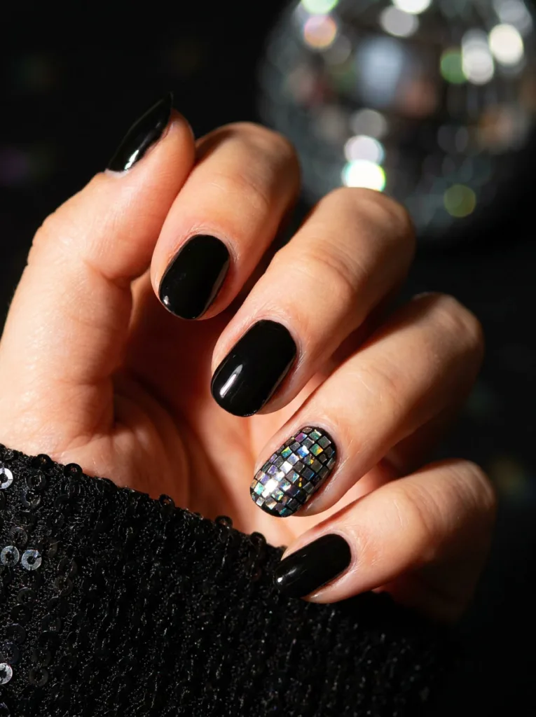 Disco ball sparkle accent nail on a glossy black new years manicure