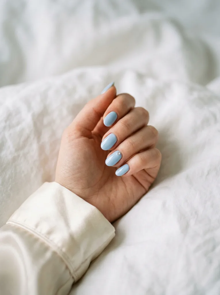 Sky blue winter nails with a minimalist crystal accent