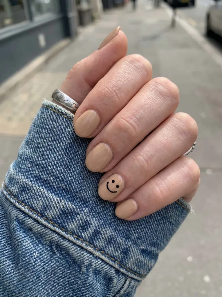 Smiley face accent nail on birthday manicure