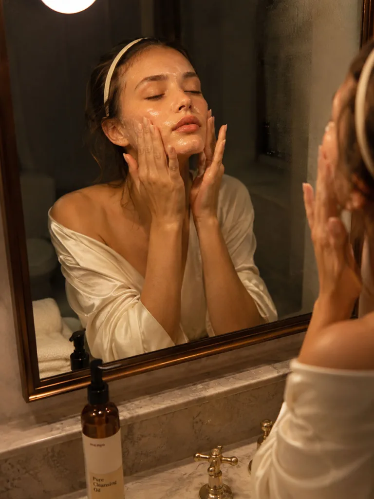 Woman applying oil cleanser during evening double cleanse routine