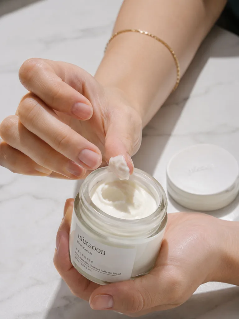 Hand scooping ceramide moisturizer from open jar