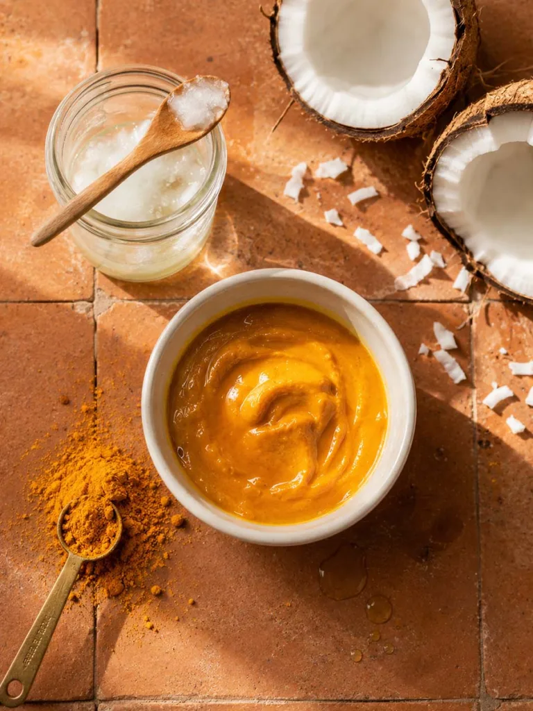 Turmeric powder and melted coconut oil styled together for a homemade radiance-boosting face mask