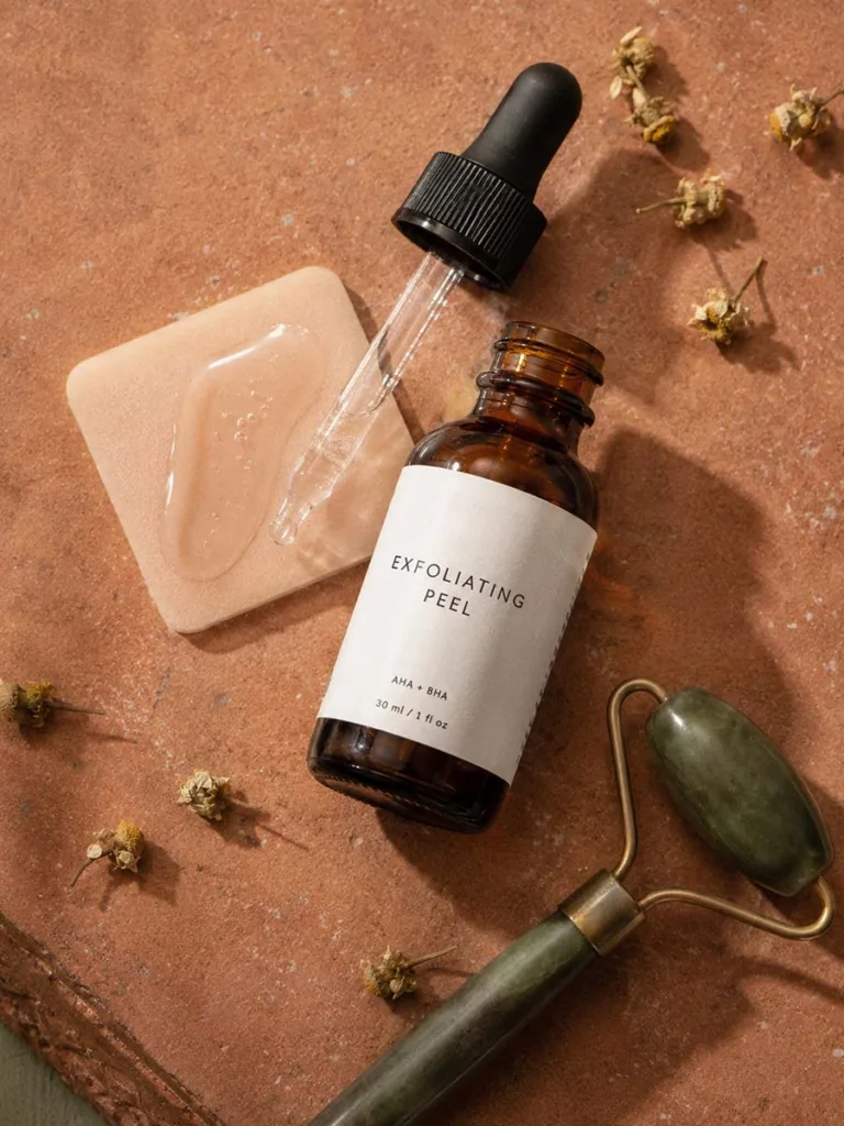 Overhead flat lay of a chemical exfoliant bottle with texture swatch on skin-toned background