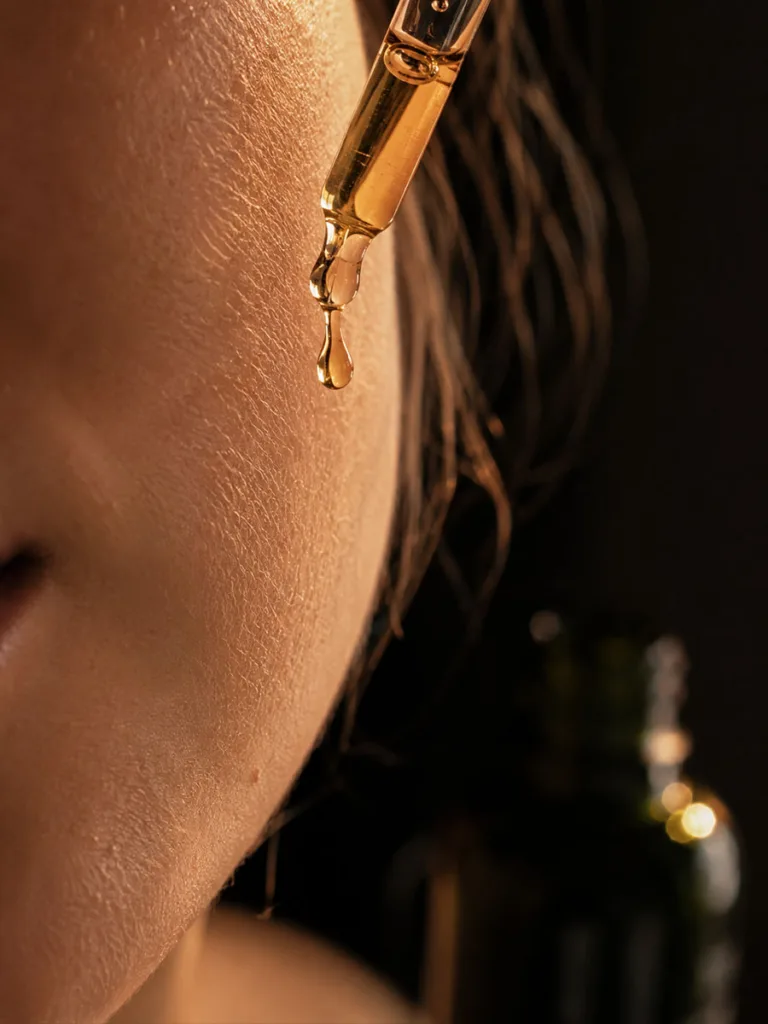 Macro shot of a serum dropper above skin applying a targeted treatment