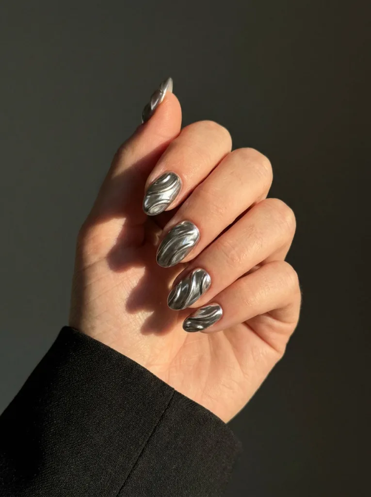 Extreme macro of fair-skinned hand with sculptural 3D raised chrome line nails under dramatic side light