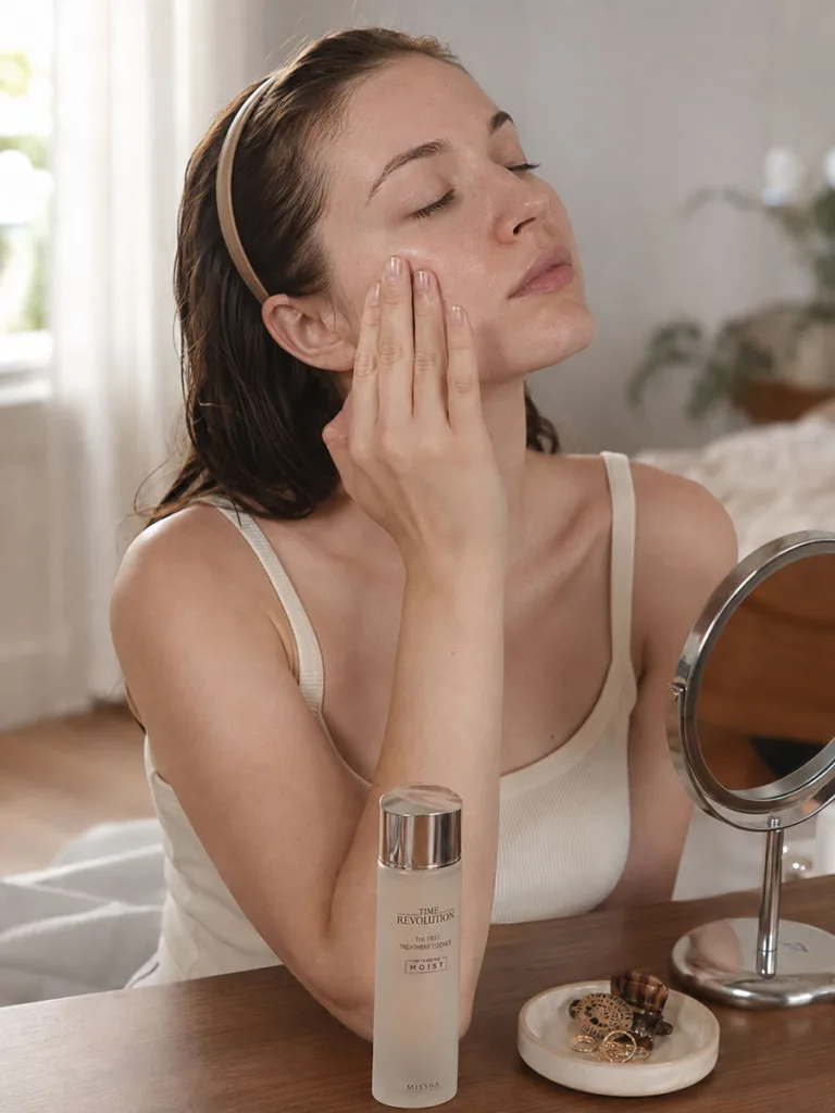 Woman with fair skin applying a fermented Korean essence to brighten dull, uneven skin tone