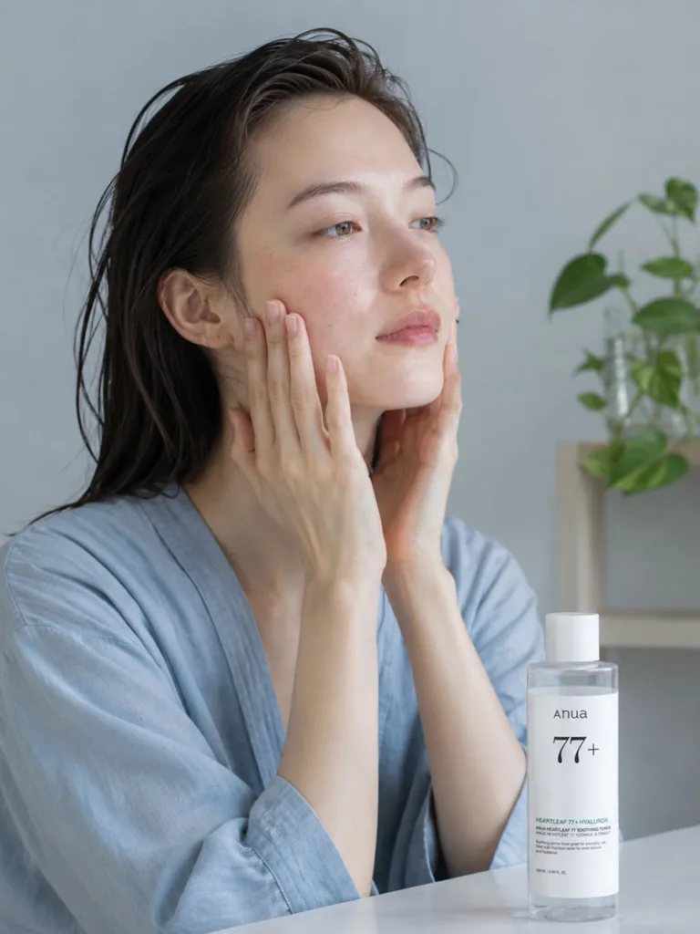 Woman with reactive, blemish-prone skin patting a calming heartleaf Korean essence into her cheek