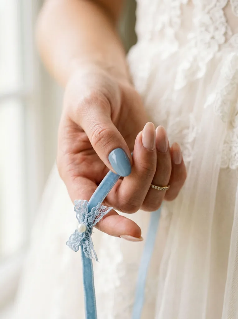 Baby blue accent wedding nail holding a blue ribbon garter detail