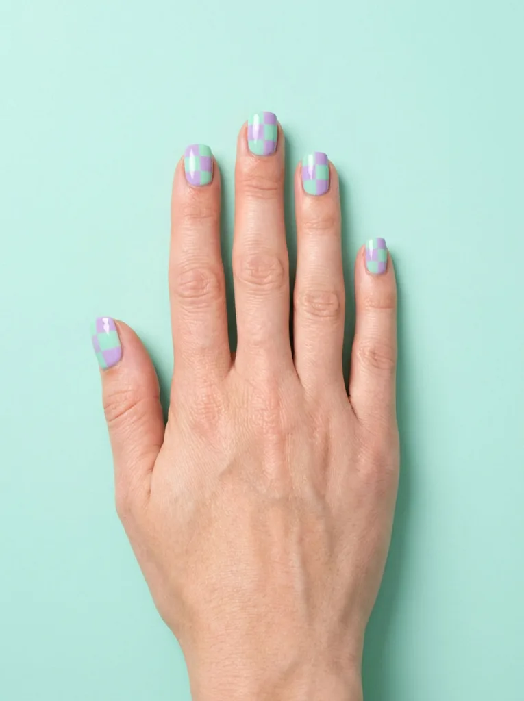 Checkerboard pastel easter nails in mint and lilac on mint tabletop