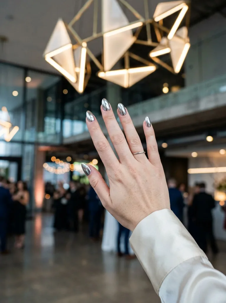 Chrome silver wedding nails reflecting modern reception venue lighting